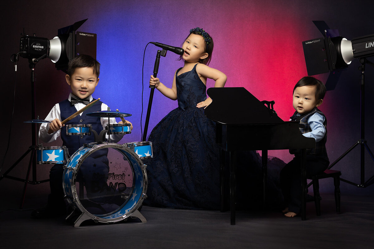 Dallas baby milestone photographer captures siblings with drums, microphone, and piano.