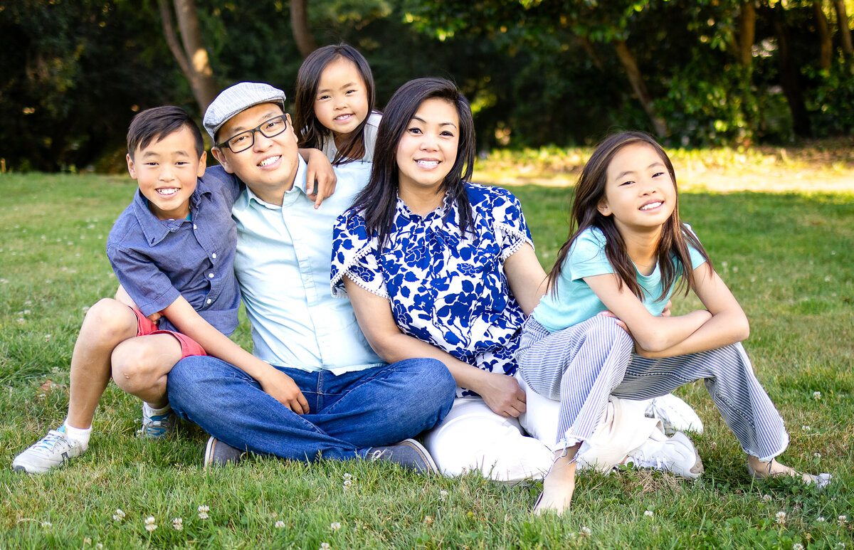 Golden hour portrait of a family of five seated in rose garden – joyful, natural light family photography by Ellobelle Photography in the San Francisco Peninsula kohl mansion Burlingame