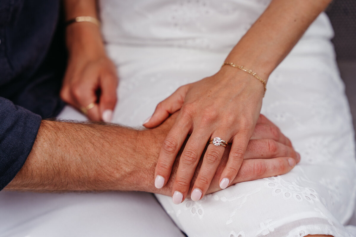 Bride and groom holding hands close-up in Dolomites