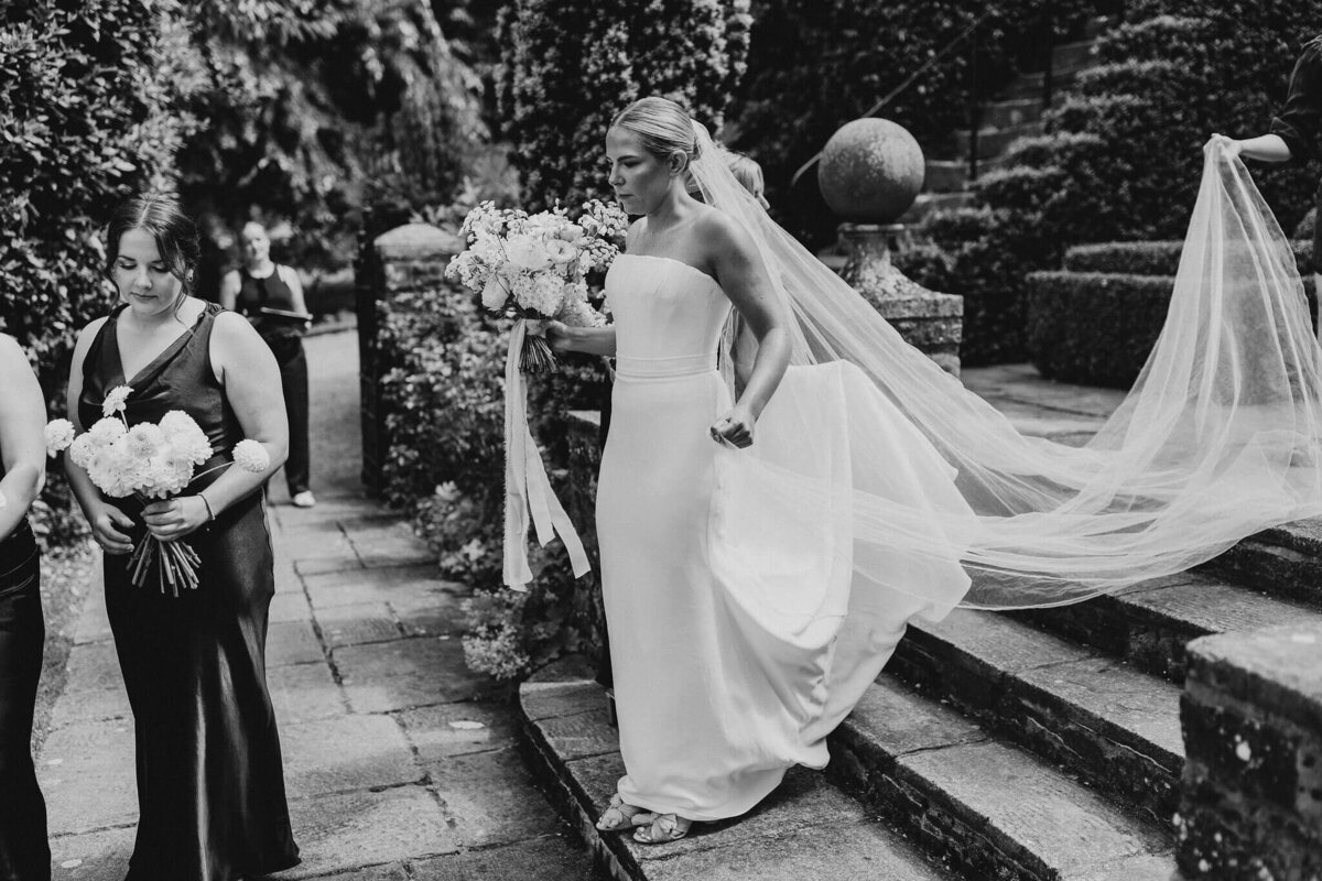 Bride walking down the steps of Dewsall Court