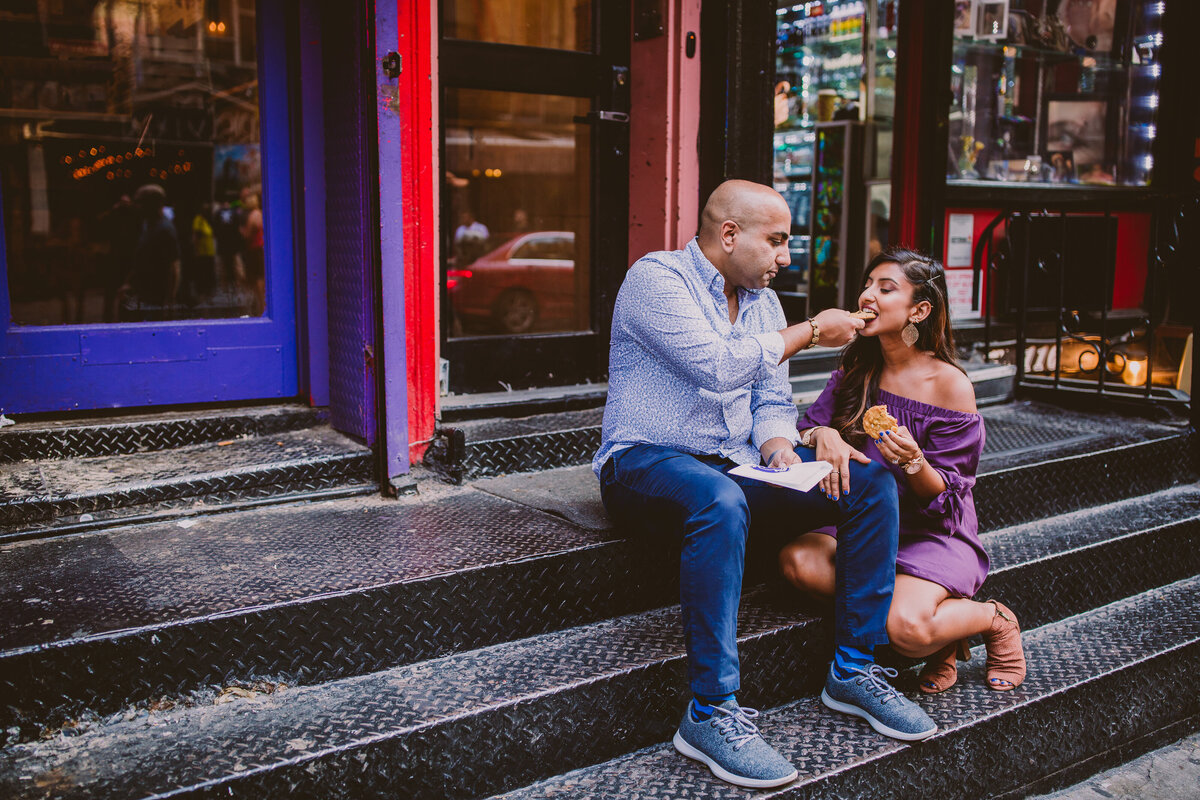 A couple sitting and eating insomnia cookies on macdougal street in nyc