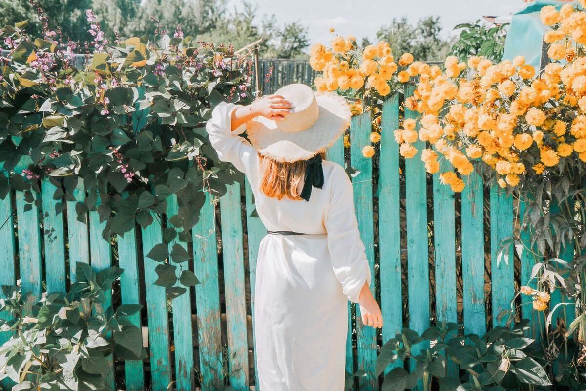 Woman holding hat and turned away to represent luxury travel concierge services