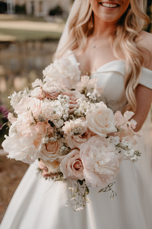 bride holding light pink bouquet