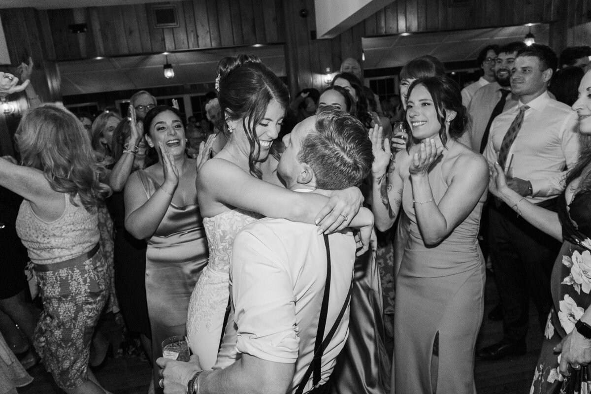 Groom lifts bride up during wedding reception at North Shore House