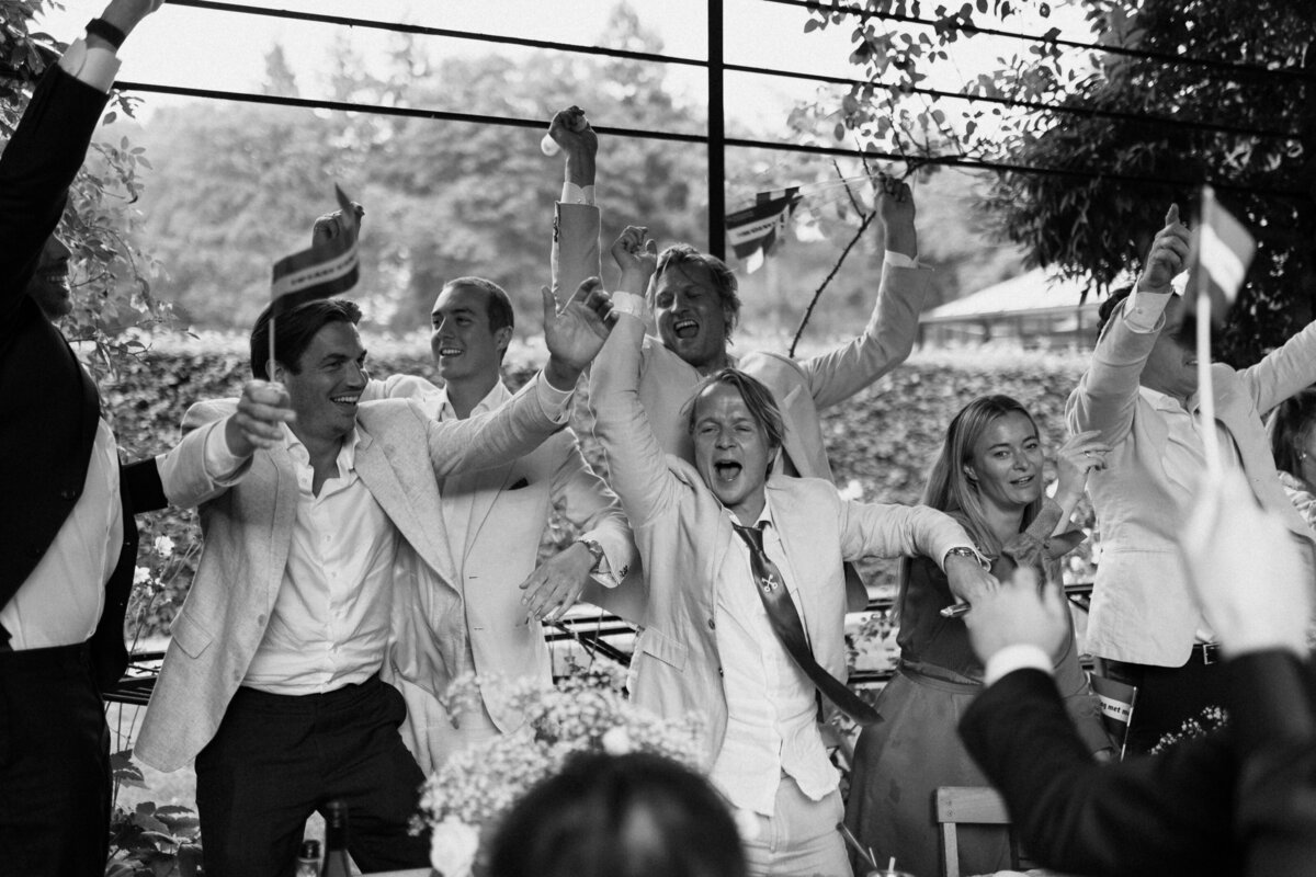 feestende gasten in pak op high end editorial bruiloft in arnhem door hanna wursten