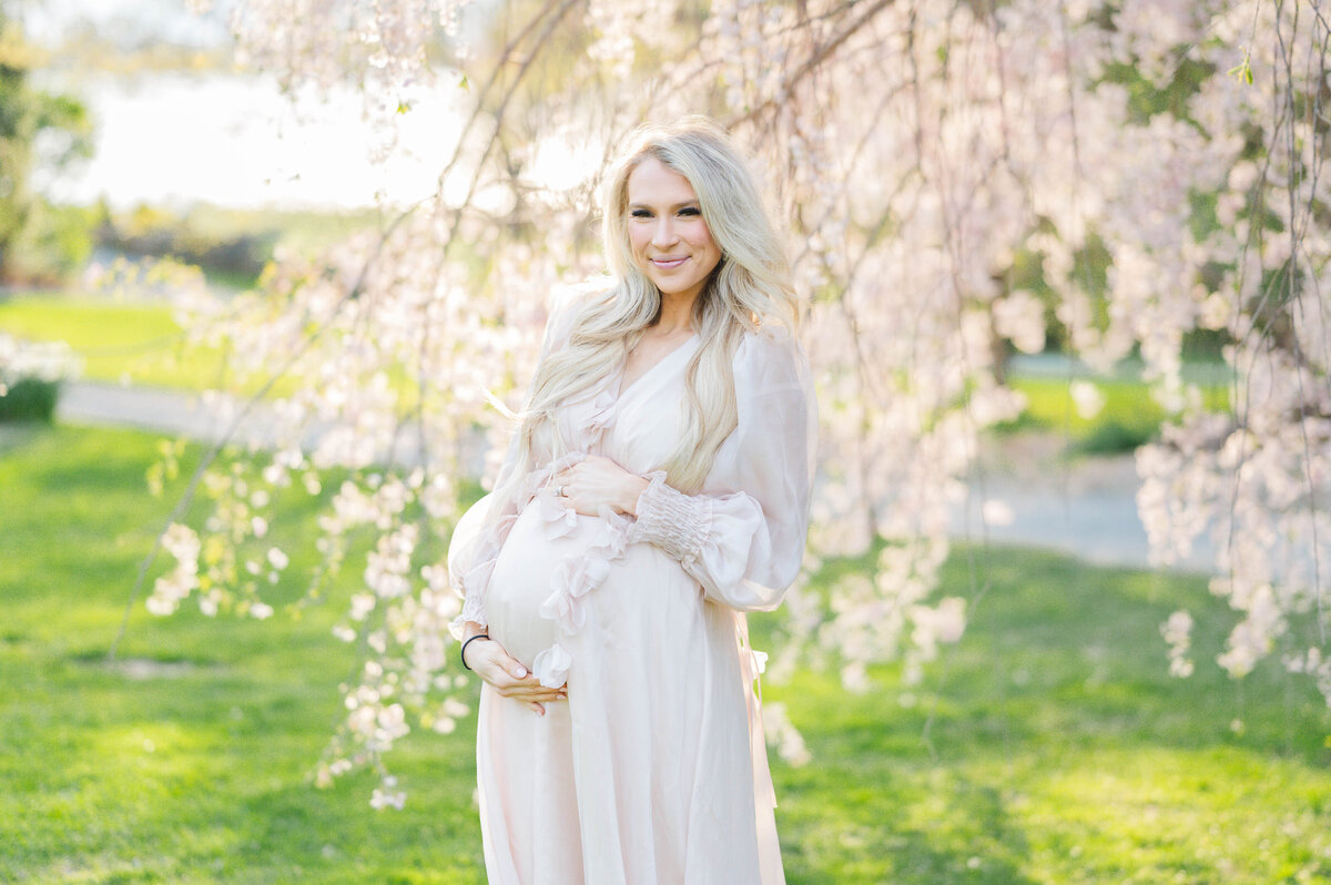 Pregnant woman holding belly in Bristol, RI at Blithewold Mansion taken by best Maternity photographer in Rhode Island
