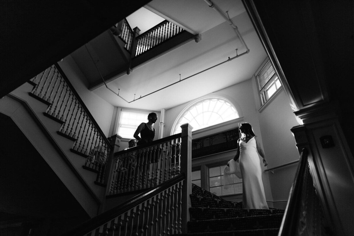 Black and white photo of the bride going down the stairs at Wianno Club, Cape Cod, MA.