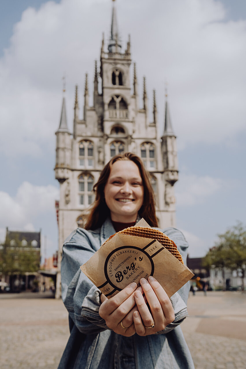 Dame met verse siroopwafel voor het Stadhuis van Gouda. 