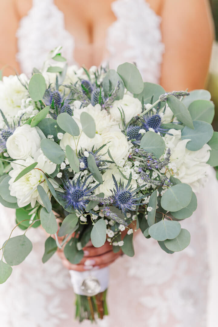 Details of a blue and white rose bouquet in bride's hands