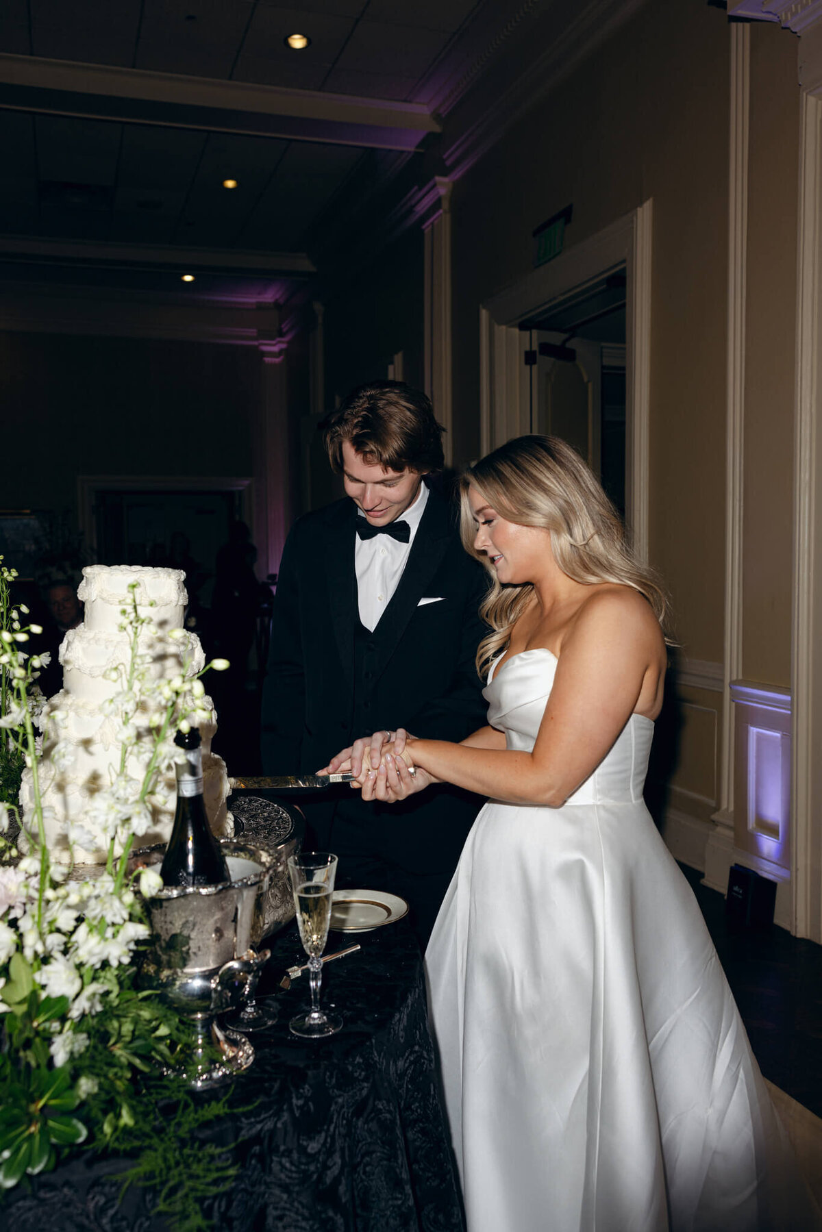 A wedding photo of the bride and groom cutting their wedding cake