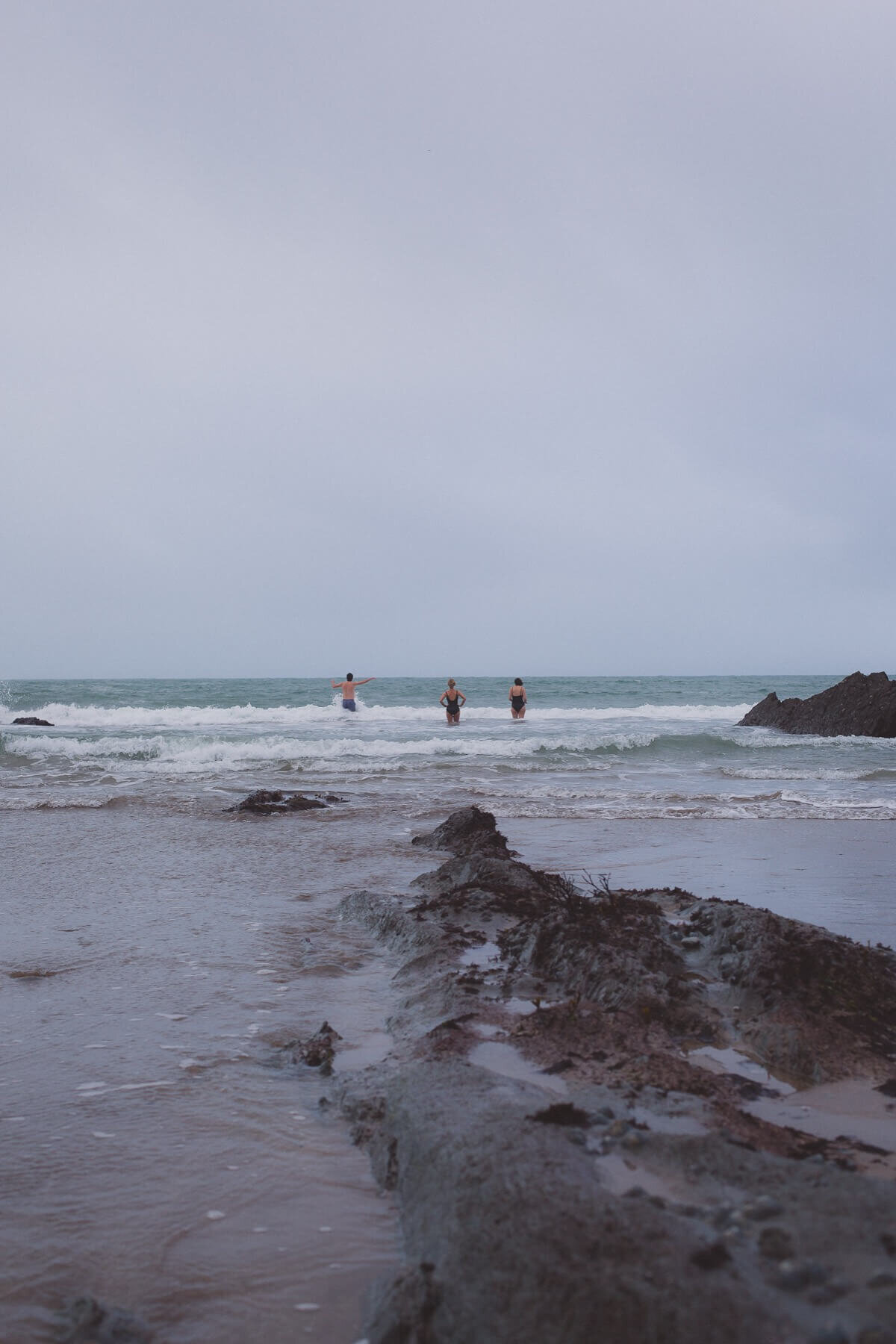 3 people standing up in the sea
