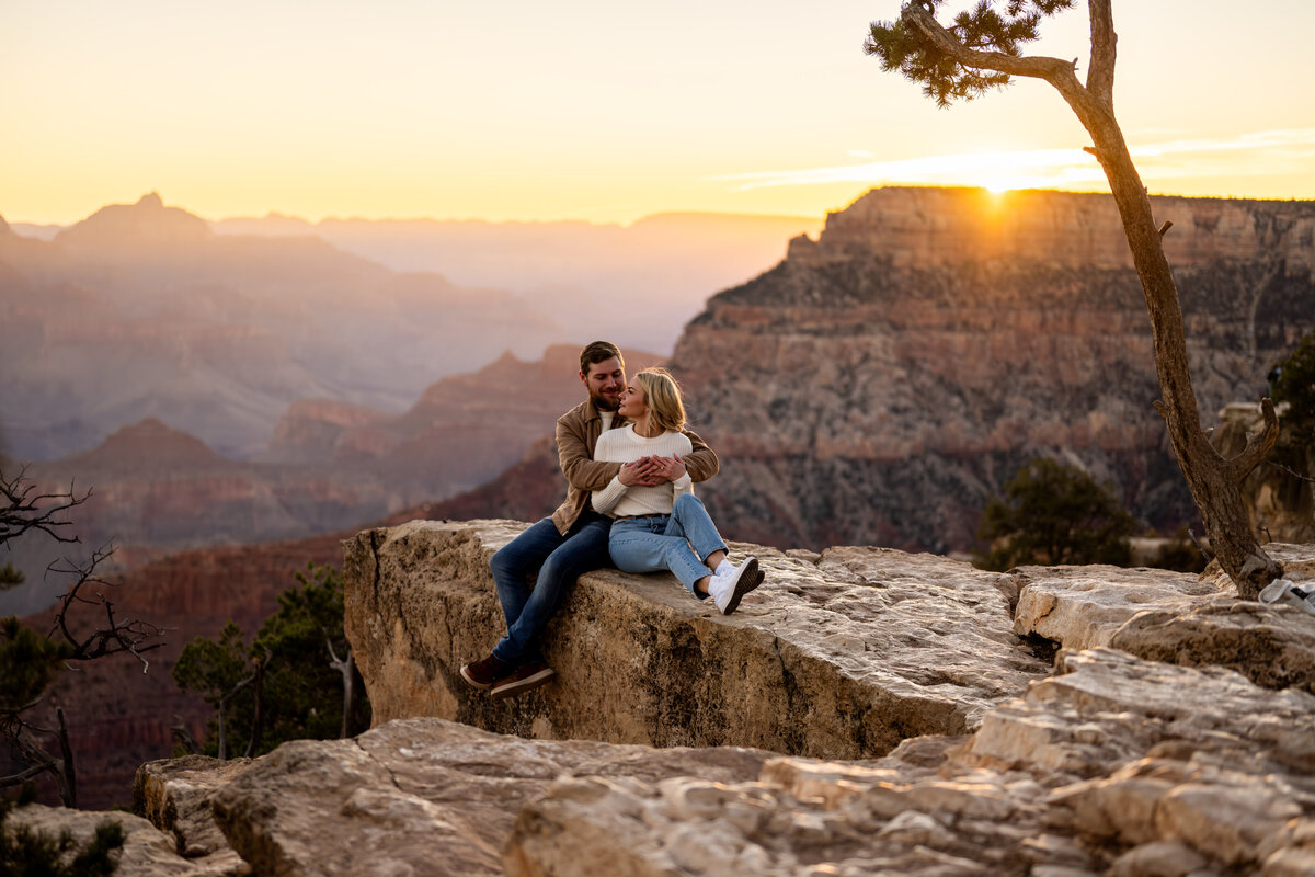Couple sharing a moment after the proposal, with the sweeping vistas of the Grand Canyon in the background.