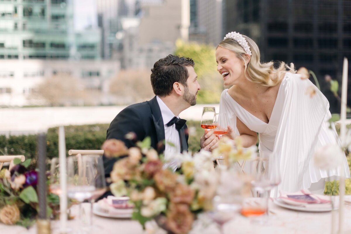 Candid photograph of a bride and groom laughing on their wedding day