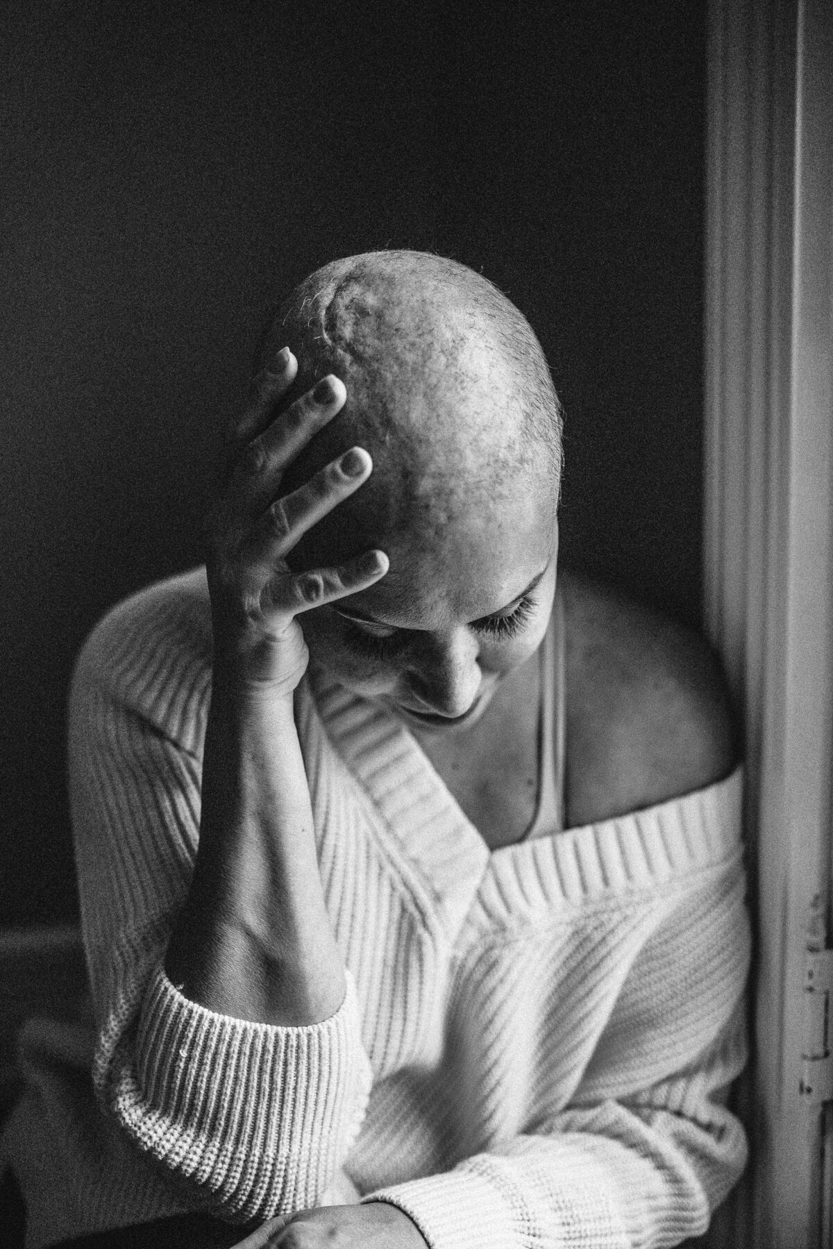 black and white image woman posing holding head