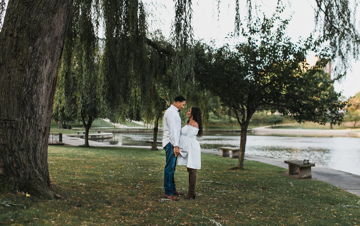 Pregnancy photoshoot with soon to be mom and dad holding hands outside.