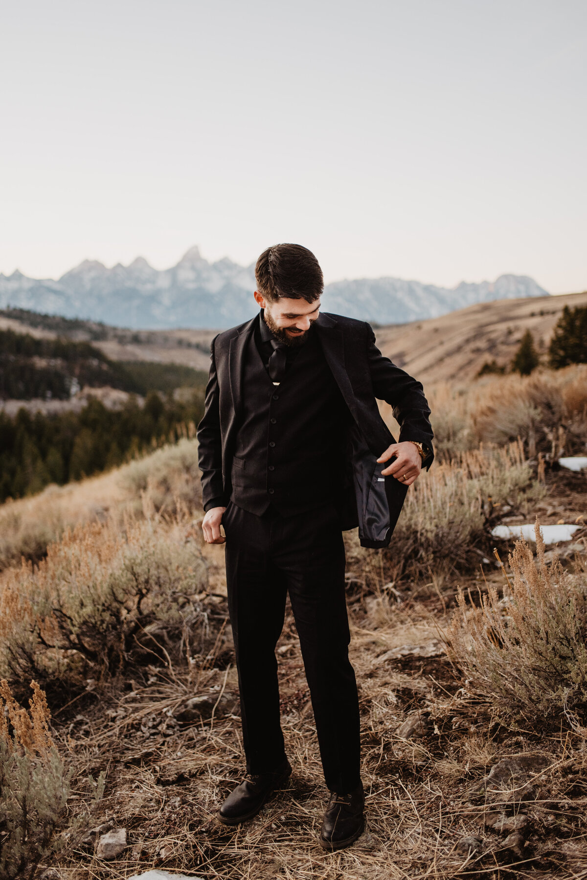 Jackson Hole Photographers capture groom looking at jacket
