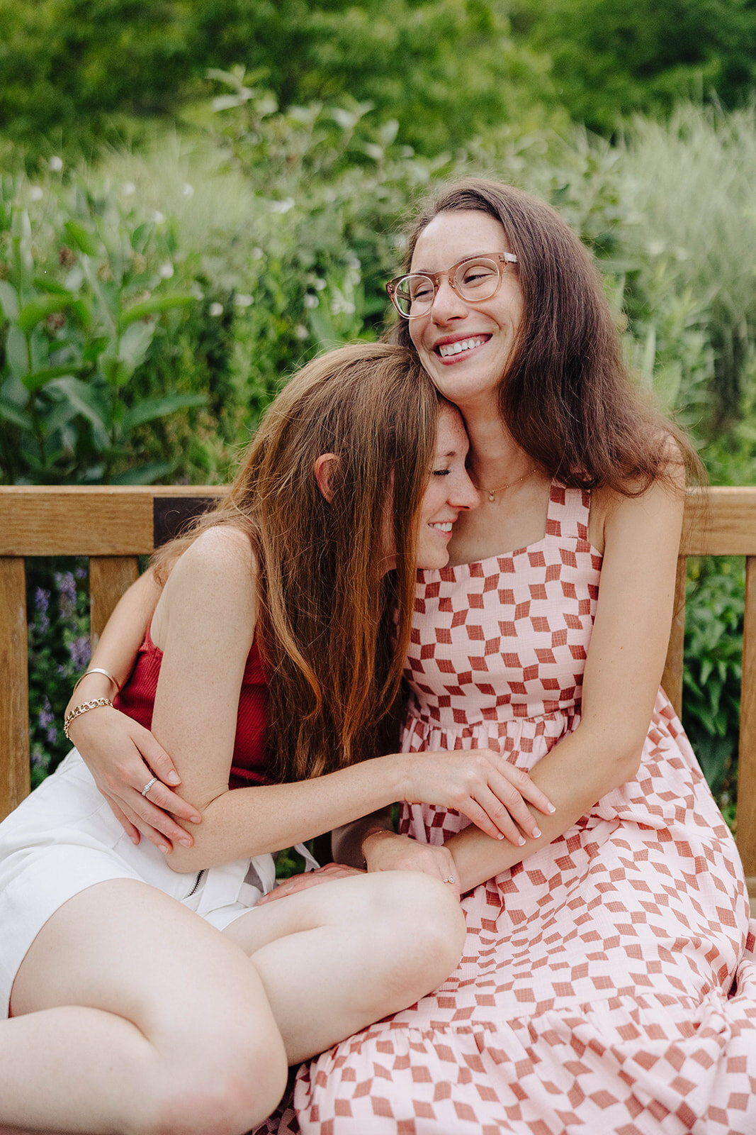 bride holding bride on a bench at Cornell University