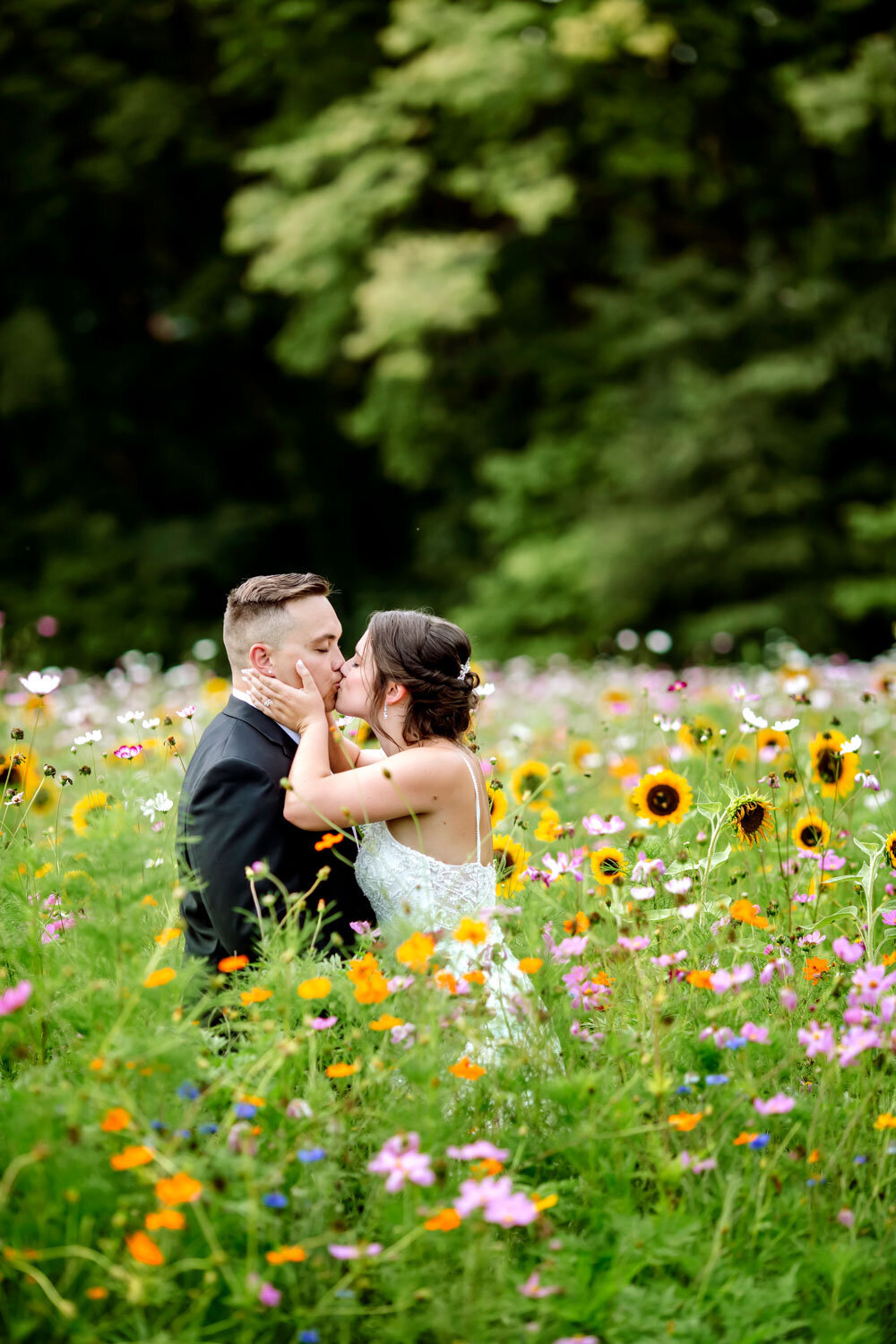 Bride and groom sharing a kiss in a vibrant wildflower field