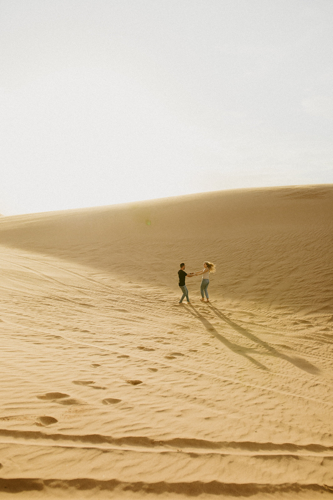Little Sahara Park Engagment Session. Couple dancing around in the sand dunes.