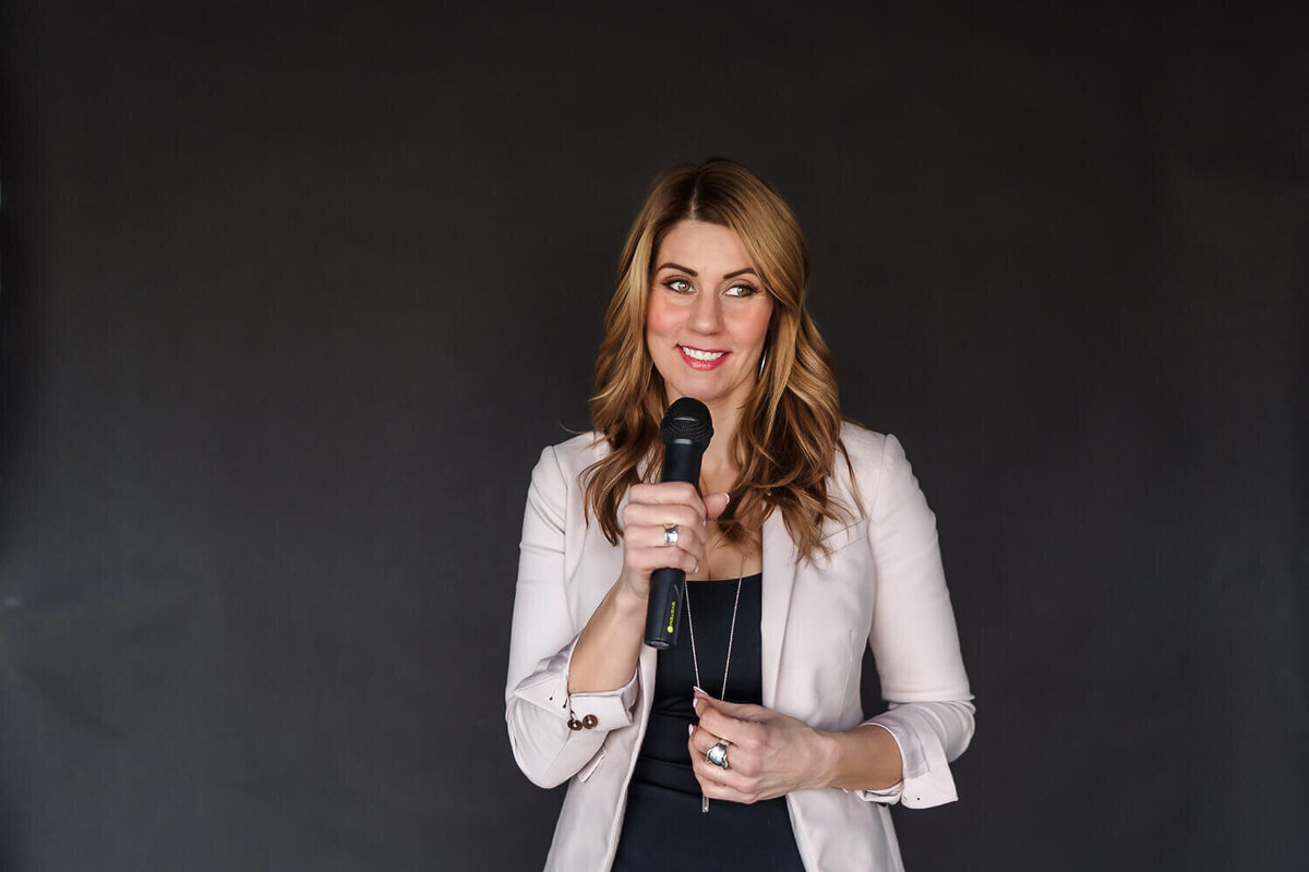 Woman speaking into handheld microphone during indoor brand photography session