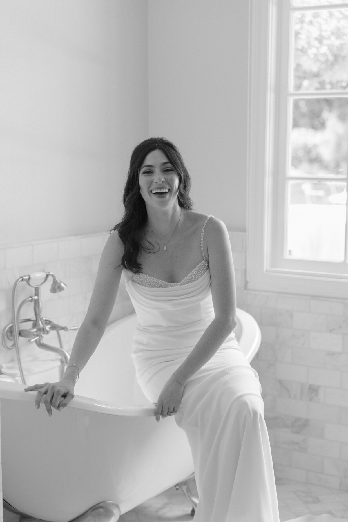 Bride laughing as she gets dressed for her wedding in Montecito 