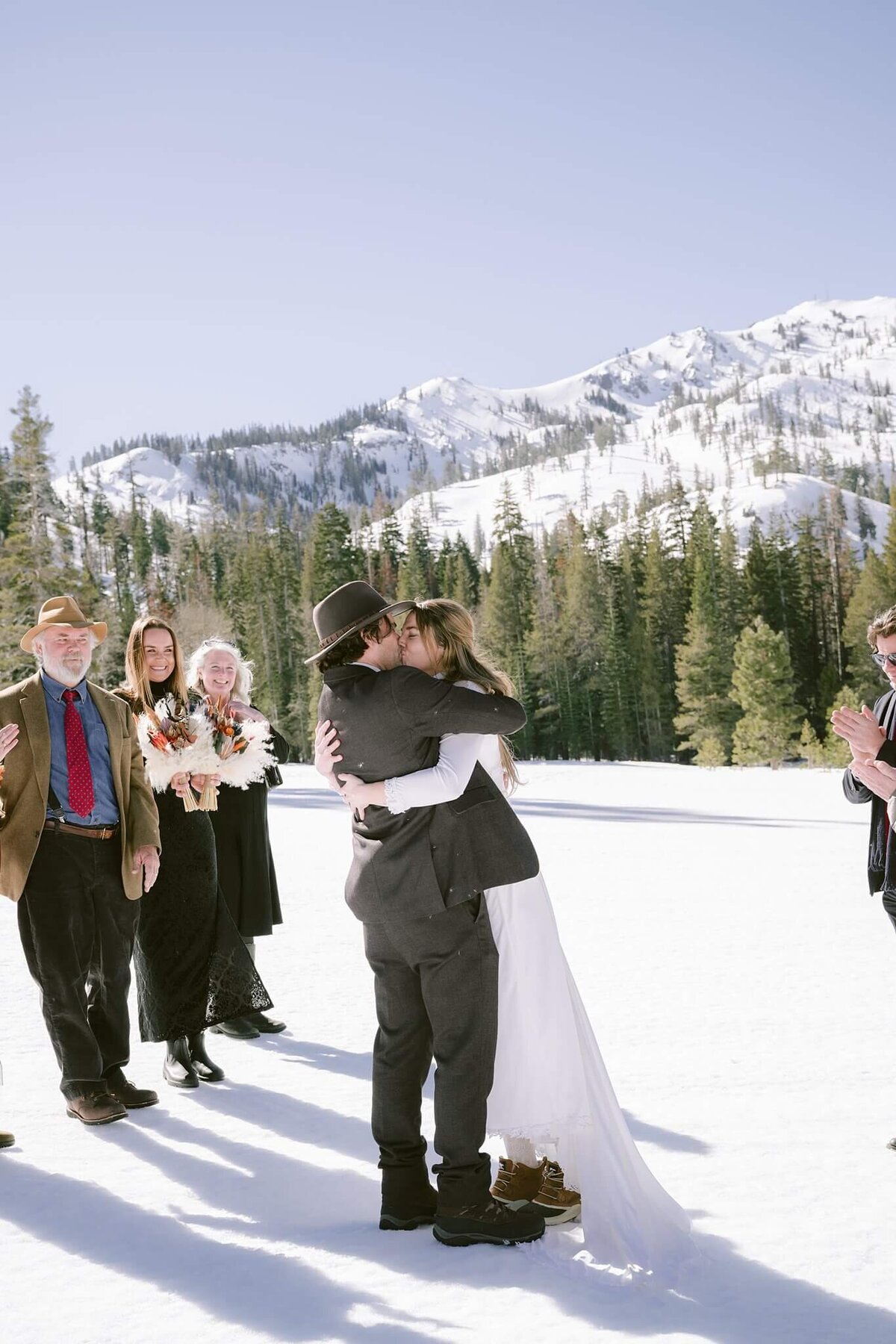 bride and groom first kiss during elopement ceremony in palisades tahoe winter eloping at it's best captured by Annie X photographie