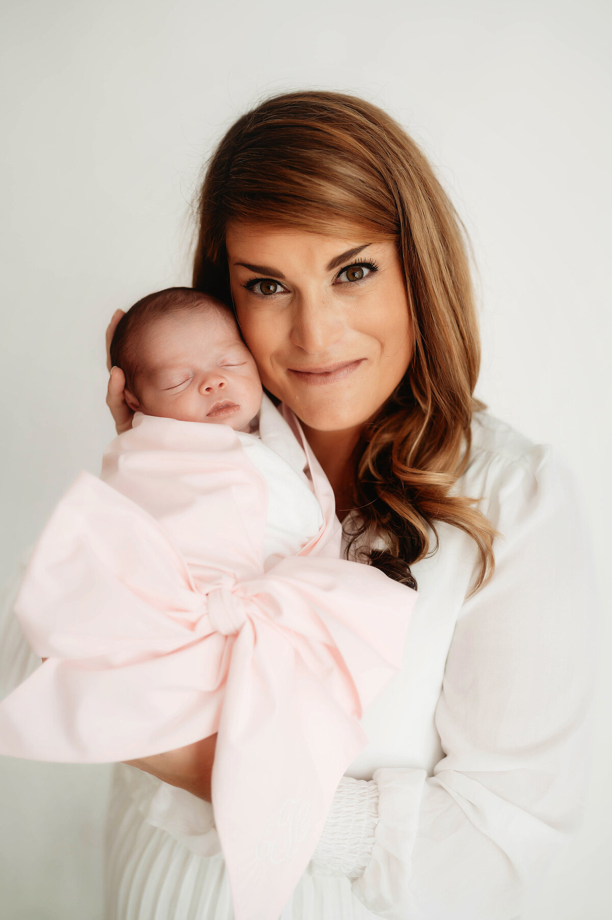Mother poses with her infant daughter during Newborn Photos in Asheville, NC.