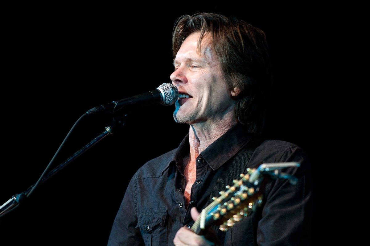 Kevin Bacon performs singing with guitar