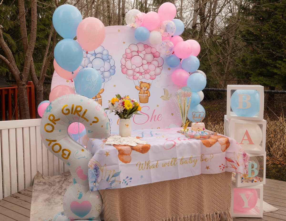 A beautifully arranged gender reveal setup, featuring confetti poppers, pink and blue decorations, and thoughtful details, all ready to celebrate the exciting news of the baby’s gender.