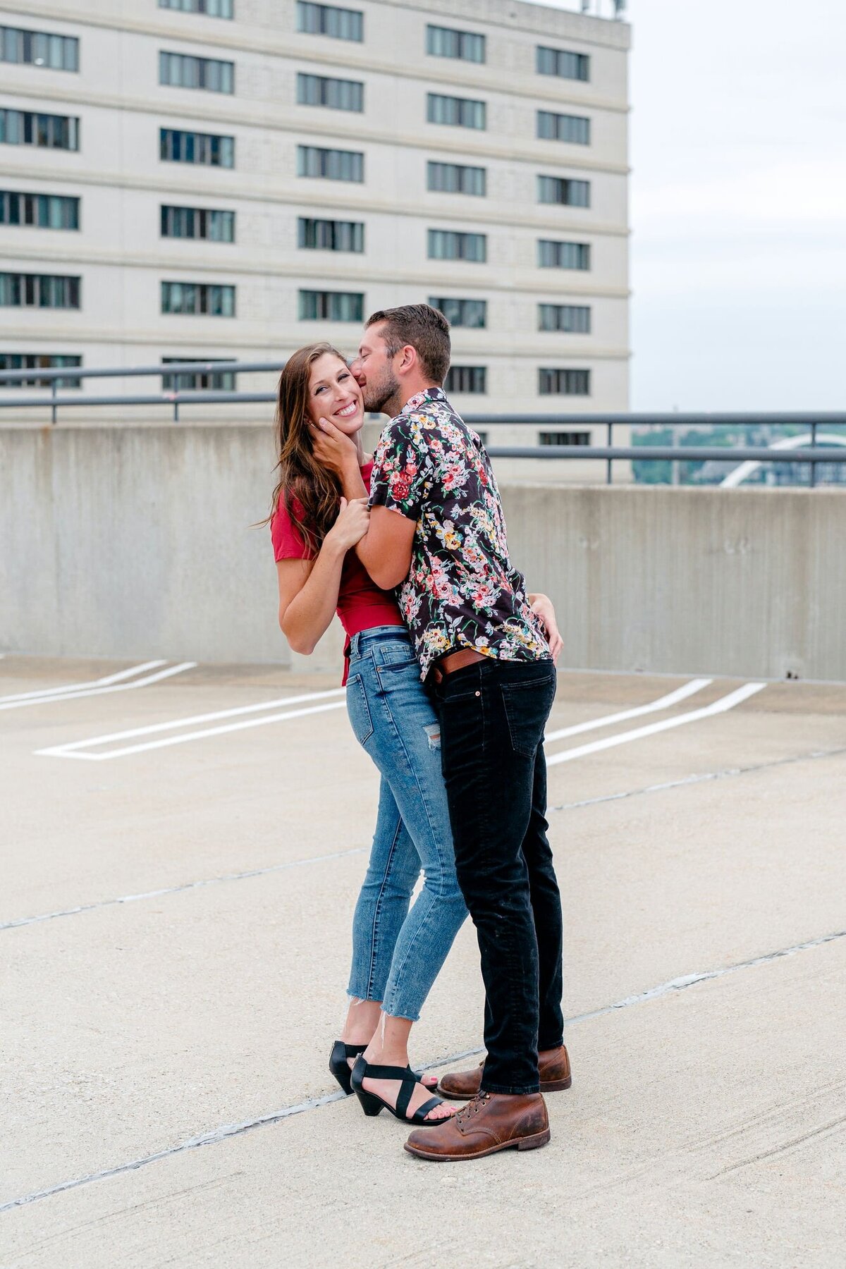 man-kissing-woman-cheek-rooftop-engagement