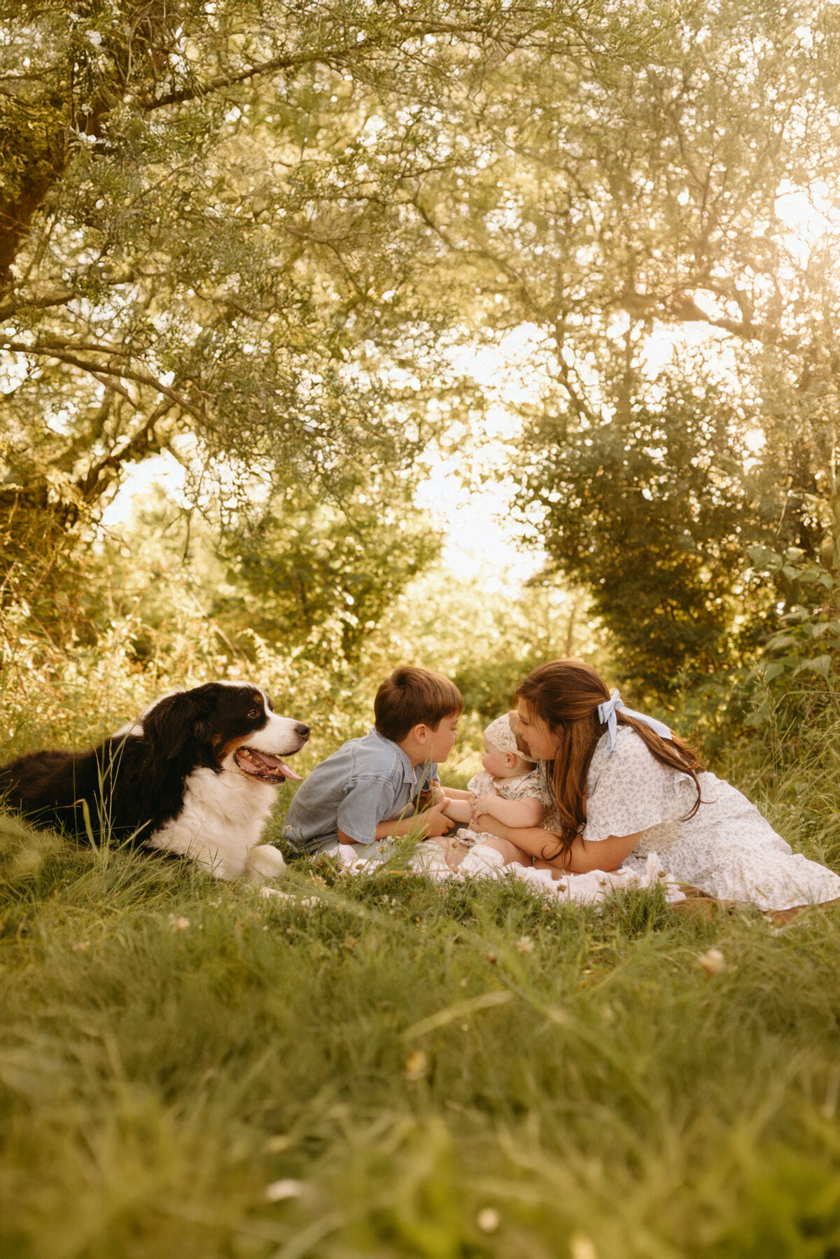 Family sitting together on bed during cozy Nashville TN in-home photography session
