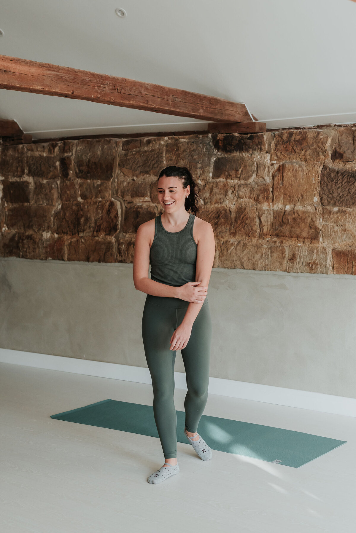 Graceful female pilates instructor teaching a pilates class at studio in East Sussex