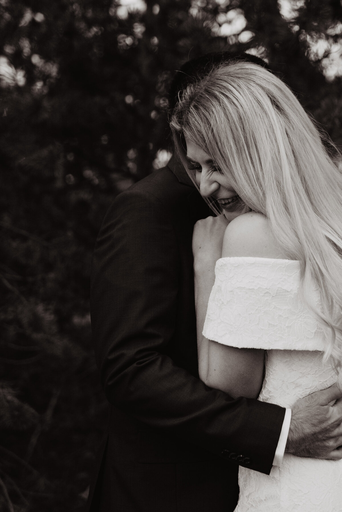 Photographers Jackson Hole capture bride laughing while groom hugs her