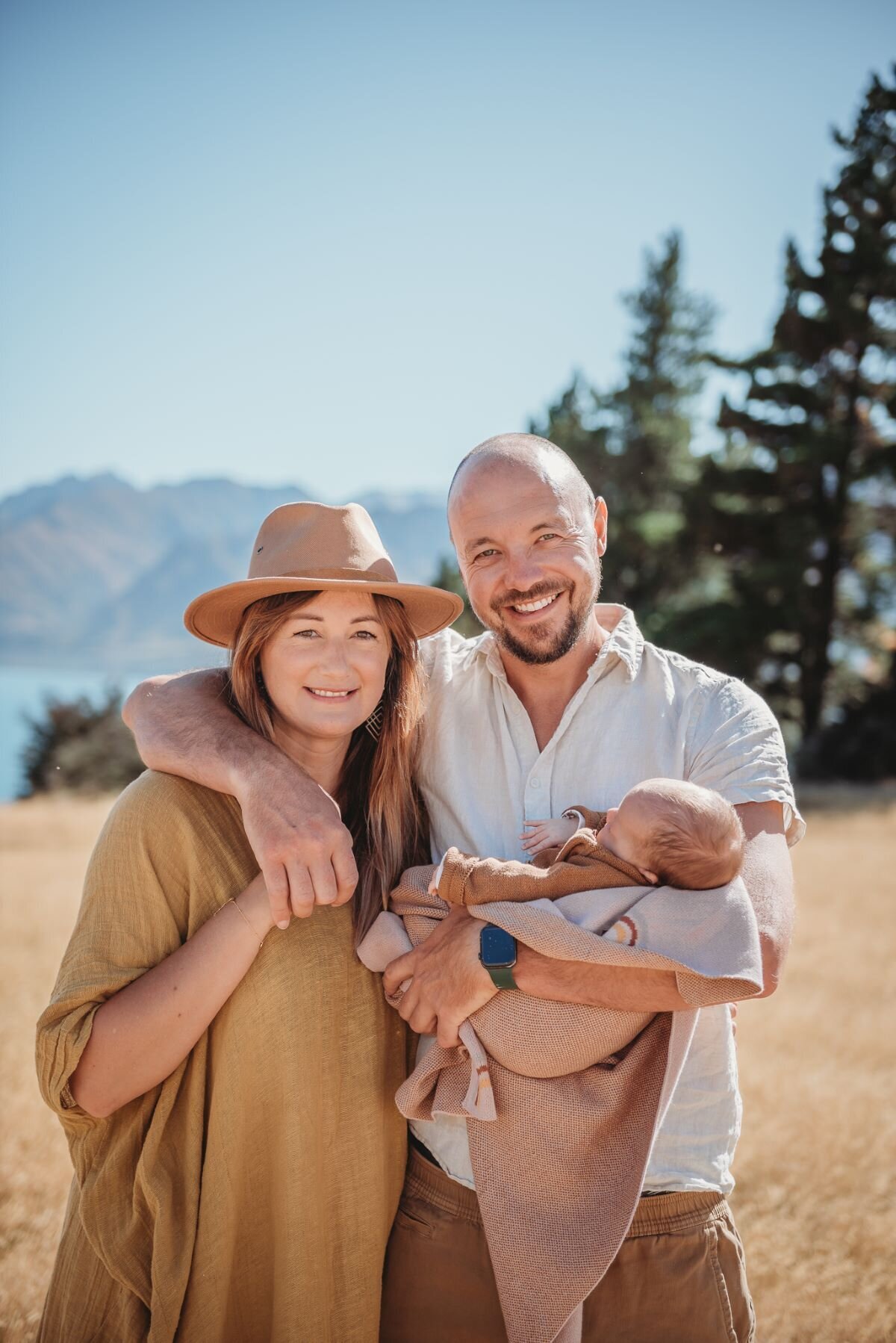 mum and dad with baby posing for a newborn photography session