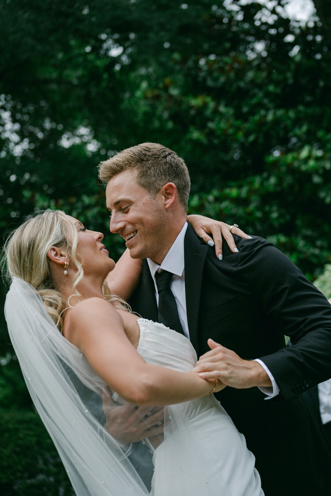 Bride and groom sharing a romantic dip during their wedding dance at an outdoor private estate ceremony and reception in Texas Hill Country, photographed by Marina Lazarine Photography.