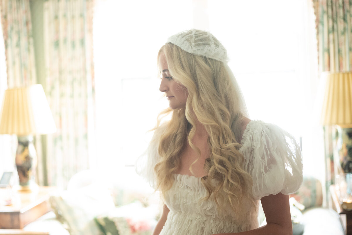 erica-renee-beauty-hair-and-makeup-duo-traveling-team-Newport-Harling-Ross-getting-ready-private-home-wedding-nyc-cool-bride-fashion-stylish-duo-long-blond-curls-cap-veil-cap-sleeves-natural-makeup-brown-lashes