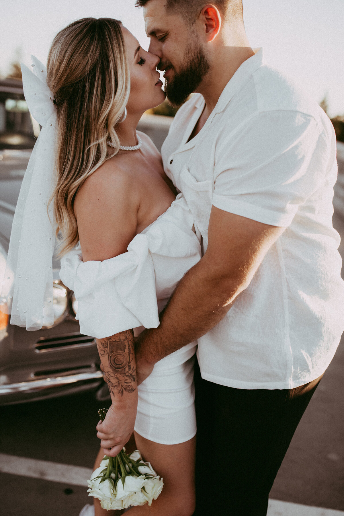 A bride and groom sharing an intimate kiss and holding each other close. 