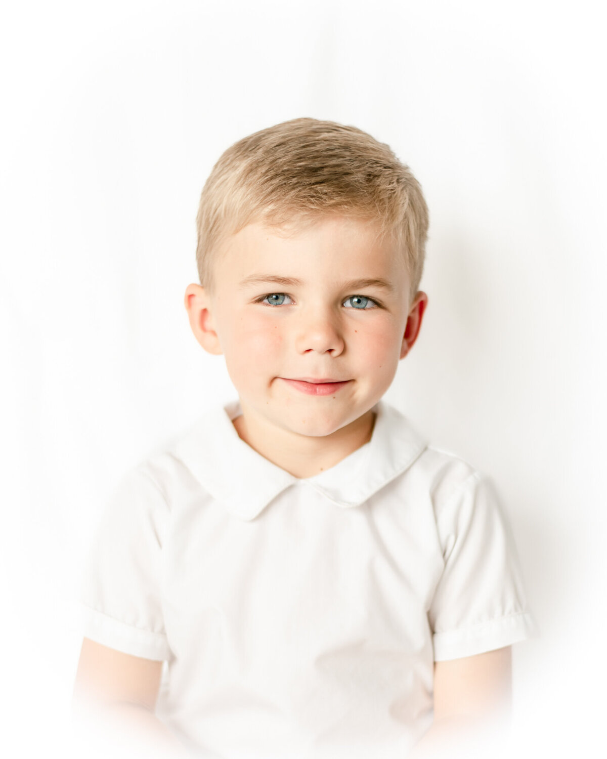 Vignetted photo of a blonde boy smiling
