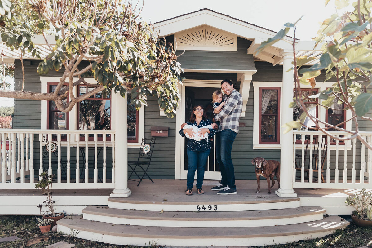 A family stands on their front porch of their San Diego home.