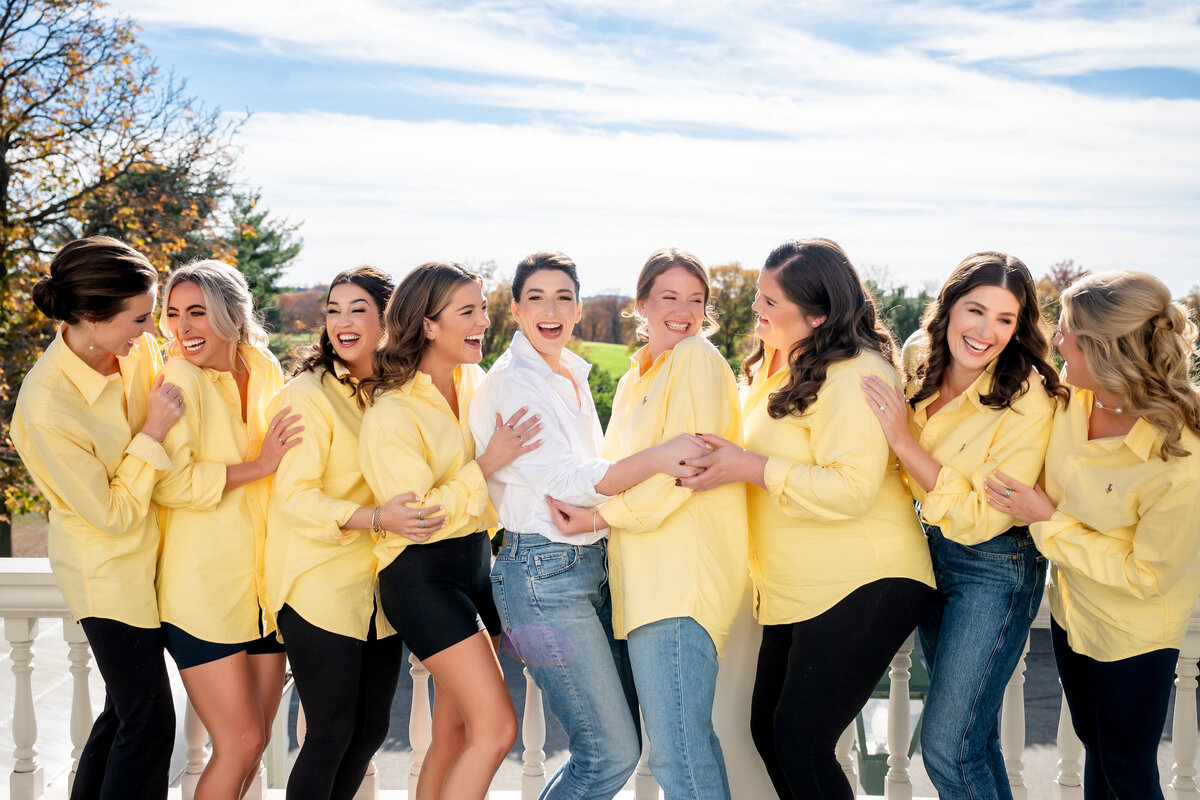 bridesmaids taking a fun wedding picture on the balcony at pittsburgh golf club