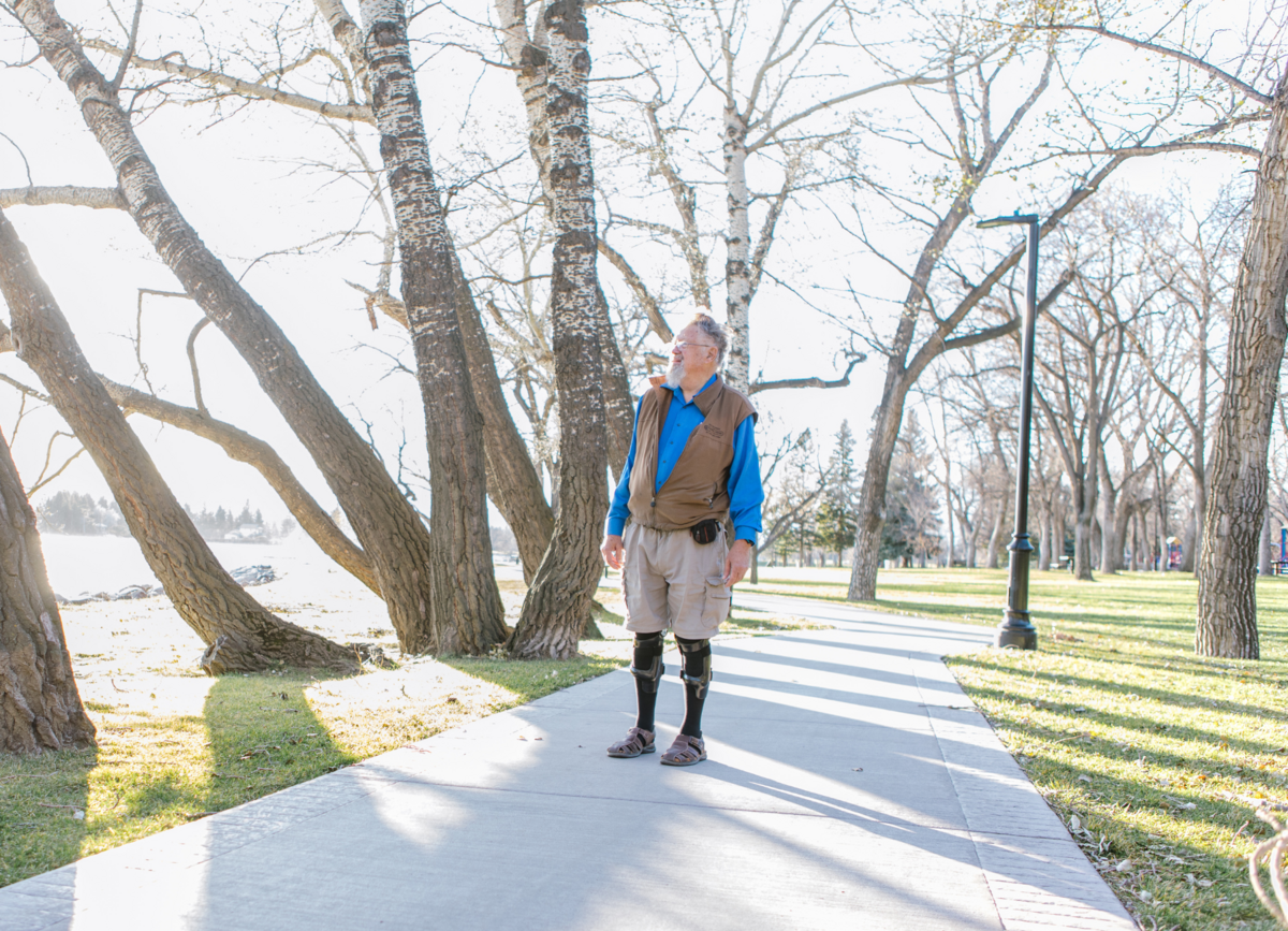 An elderly standing with a knee support, an orthosis device crafted for stability.
