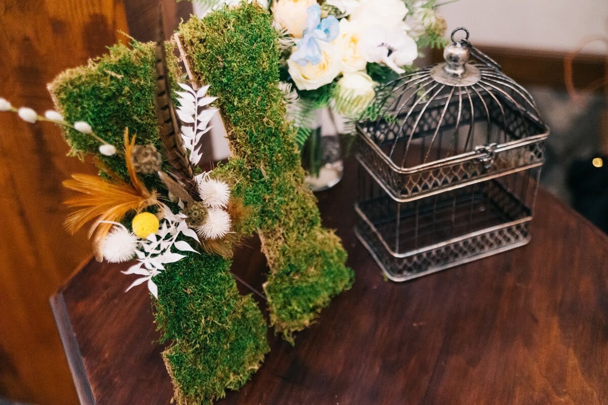 Bird cage and floral details for indoor wedding ceremony in Eugene.