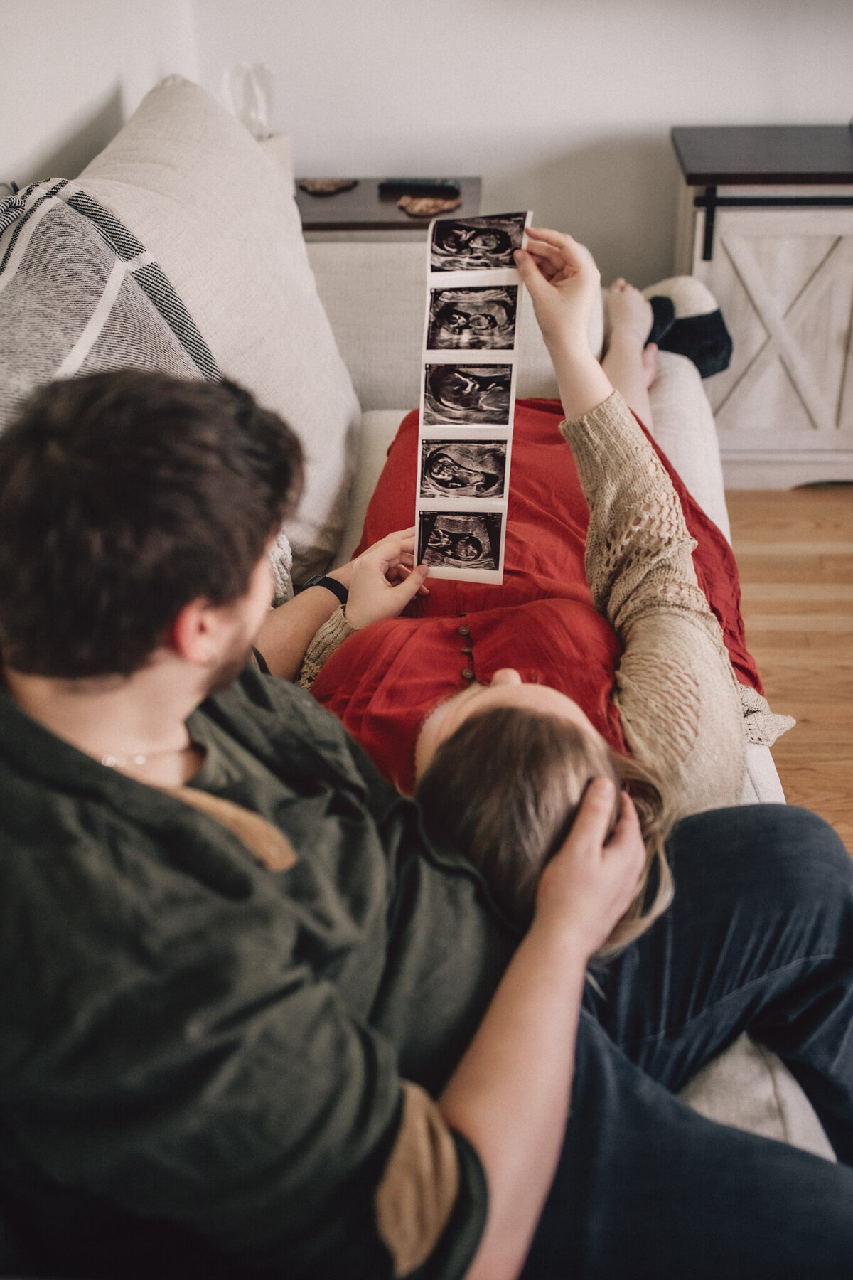 couple holding ultrasound photos