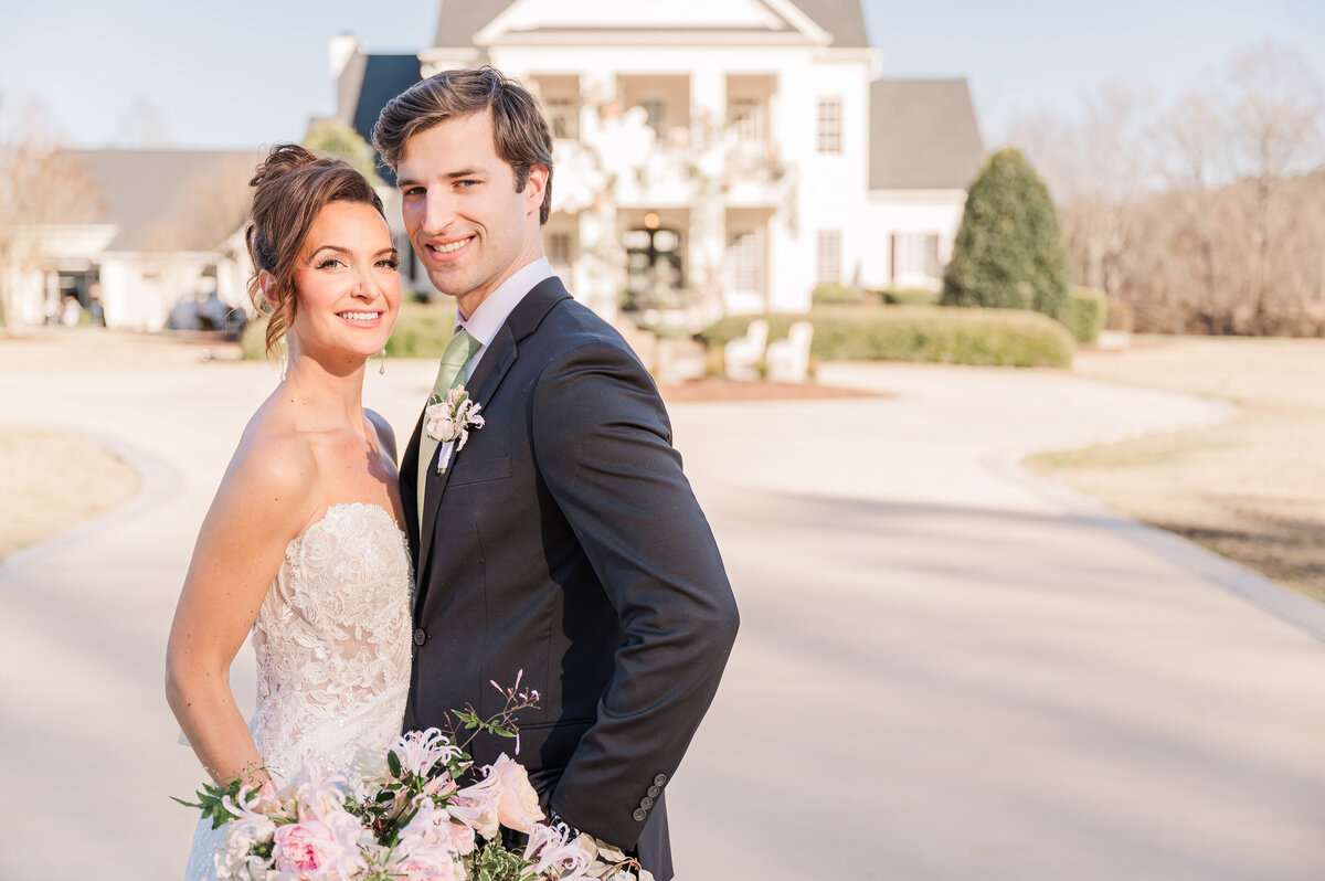 A happily married couple smiling outside of Donovan Manor at sunset enjoying their Raleigh wedding photos