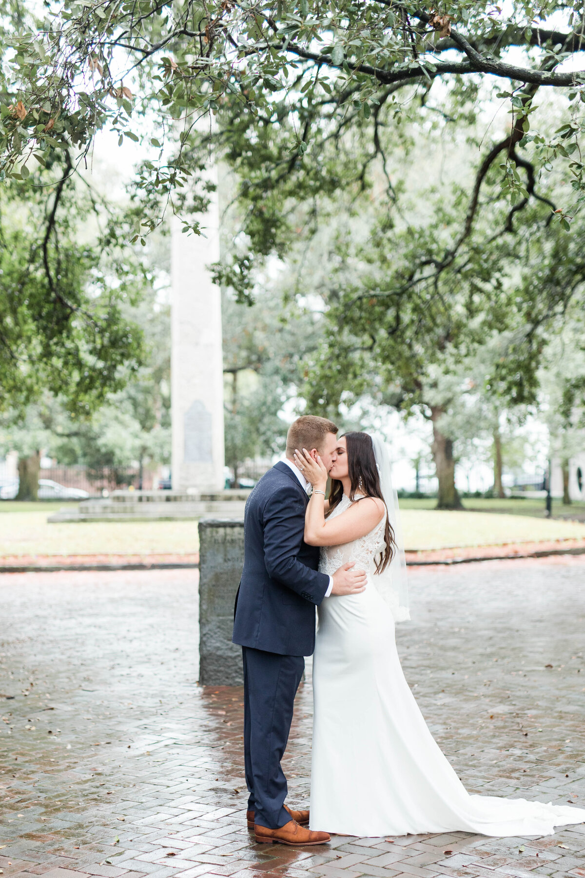 bride and groom kissing rainy charleston wedding