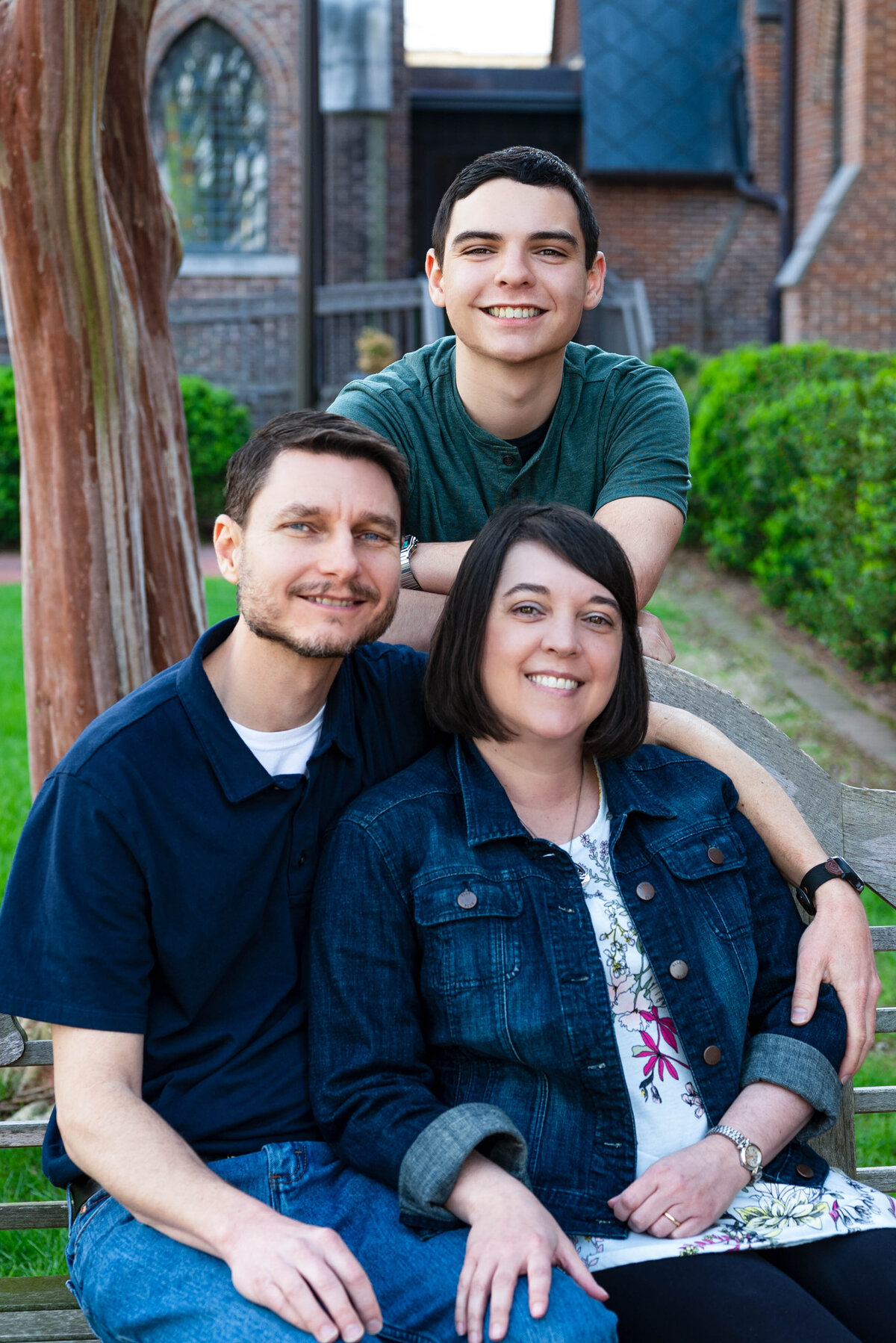 Parents pose with their teenage  son for family pictures in downtown Huntsville Alabama