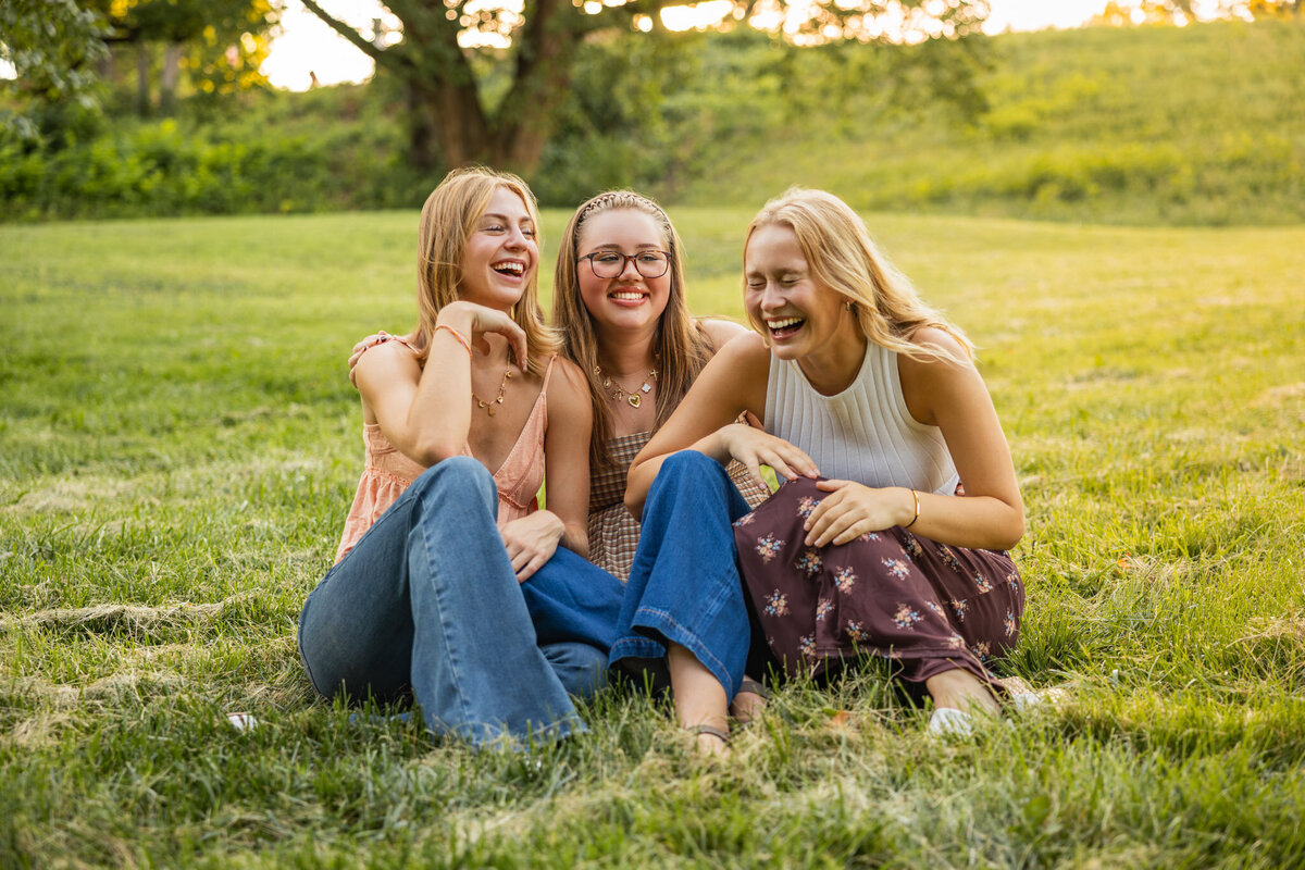 MBP Senior Team sitting on a grass field laughing at a joke in Lawrence, KS