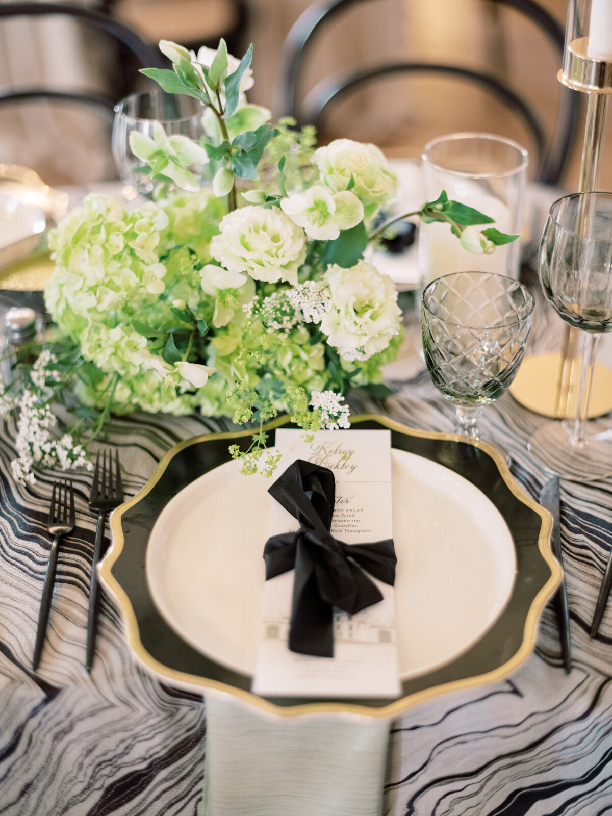 This image presents a stylishly arranged table adorned with elegant decor, featuring lush floral accents, exquisite glassware, and an inviting atmosphere for weddings.