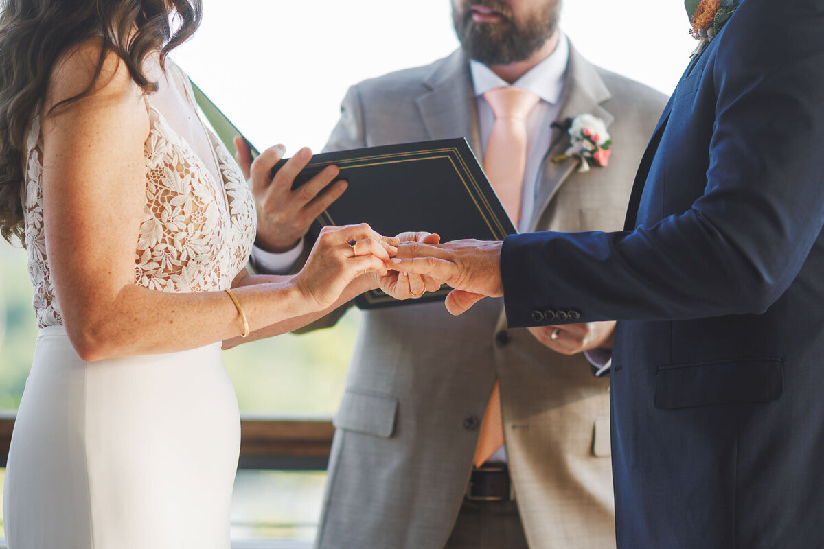 Bride putting on ring on the groom