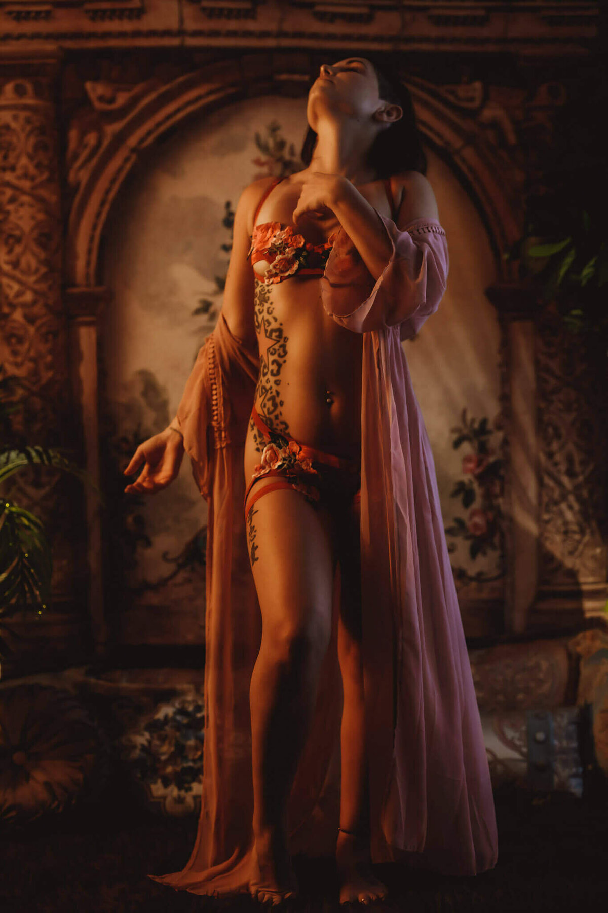 Woman in floral lingerie and a sheer robe standing in front of a backdrop in a DFW boudoir studio